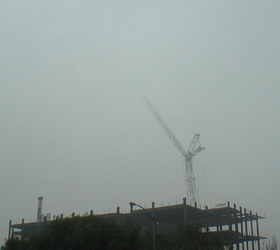 Downtown construction, as a crane disappears in the fog...
